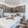 Apartments in Northwest Reno NV - The Retreat - Designer Kitchen with White Countertops, Brown Cabinetry, and Stainless Steel Appliances.