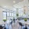 Large well lit clubhouse with ample seating large windows and a fire place 