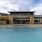 Large sparkling blue pool with a large pool deck and lounge chairs