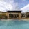 Large sparkling blue pool with a large pool deck and lounge chairs