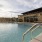 Large sparkling blue pool with a large pool deck and lounge chairs