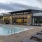 Large sparkling blue pool with a large pool deck and lounge chairs