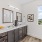 Apartments Northwest Reno For Rent - The Retreat - Bathroom With Custom Cabinetry, Double Vanity Mirrors, Dual Sinks, Wood-Inspired Flooring, And A Window
