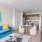 Apartments Northwest Reno - The Retreat - A spacious and well-lit living room with wood flooring, large windows, and open access to the kitchen