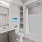 Large well lit bathroom with white accents 