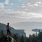 Lady standing on a rock over looking a valley 